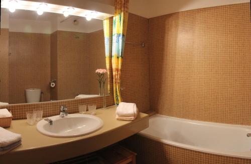 une salle de bain avec un lavabo, une baignoire et un miroir dans l'établissement Vacances à Bidart-Plage, à Bidart