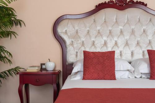 a bedroom with a white bed with red pillows at Hotel Mayer & Splendid - Wellness e Spa in Desenzano del Garda