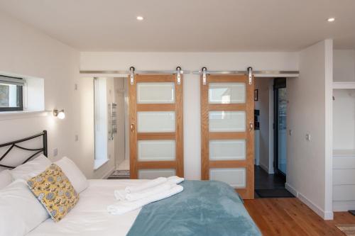 1 dormitorio con 1 cama con sábanas blancas en Croft 7 Geary Self Catering Studio with stunning sea views en Geary