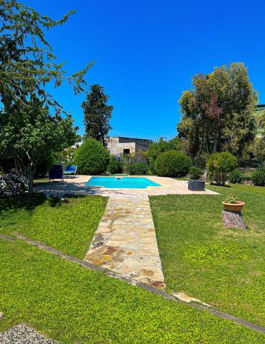 a backyard with a swimming pool and a grass yard at Tra Terra e Mare in Flumini di Quartu
