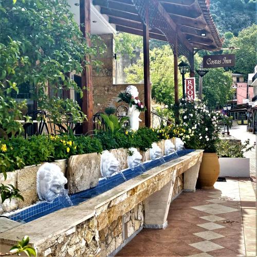 a stone bench with flowers and plants on it at Costas Inn in Spílion