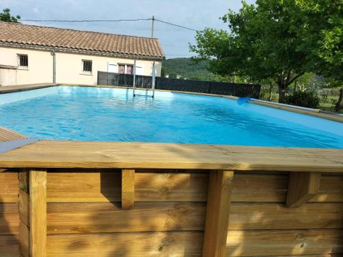 a swimming pool with a wooden fence and a wooden deck at Cottage in Lagorce in Lagorce