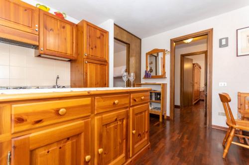 a kitchen with wooden cabinets and a dining room at Condominio Le Marmotte in Selva di Cadore