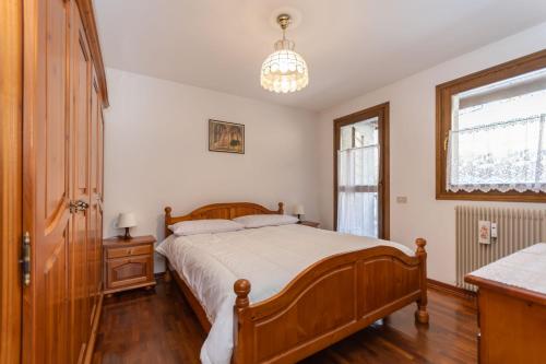 a bedroom with a large bed and a window at Condominio Le Marmotte in Selva di Cadore