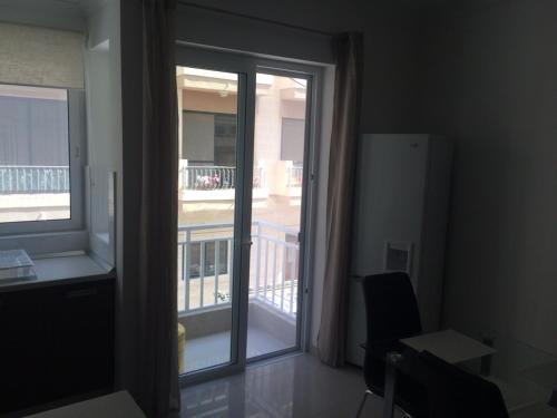 Camera con porta scorrevole in vetro e balcone. di Cozy 1 bedroom apt very close to the seaside B1B a San Pawl il-Baħar