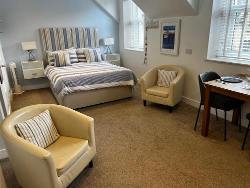 a bedroom with a bed and a desk and chairs at Wenden Guest House in Newquay