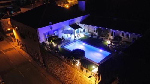 an overhead view of a house with a swimming pool at night at Casa do Adro in Viana do Castelo