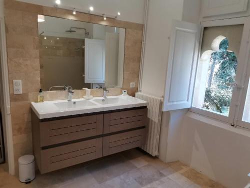 baño con lavabo y espejo grande en Château la Sable, chambres d'hôtes, en Cucuron
