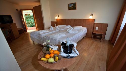 Habitación de hotel con cama y mesa con fruta en Aqua Therm Hotel, en Zalakaros