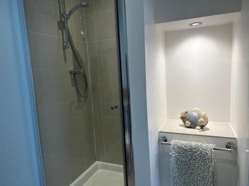 a shower with a glass door next to a toilet at Wenden Guest House in Newquay