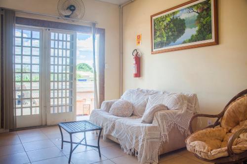 ein Wohnzimmer mit einem Sofa und einem Tisch in der Unterkunft OYO M&J Hotel in Santo Antônio do Descoberto