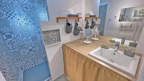 La salle de bains est pourvue d'un lavabo et d'un comptoir avec un miroir. dans l'établissement Les Coralies, à Sainte-Maxime