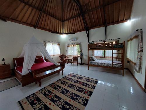 a living room with a bed and a bedroom with a rug at Hibiscus House Pemuteran Bali in Pemuteran