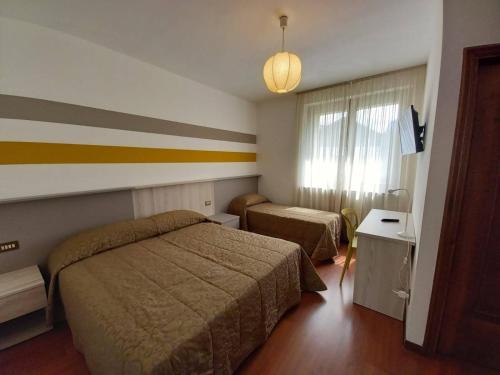 a hotel room with two beds and a window at Mortirolo -Imperial Rooms in Grosotto
