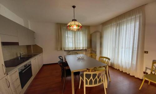 een keuken en eetkamer met een tafel en stoelen bij Mortirolo -Imperial Rooms in Grosotto