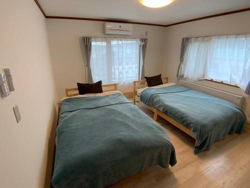 sypialnia z 2 łóżkami i oknem w obiekcie TY-Home w mieście Asahikawa