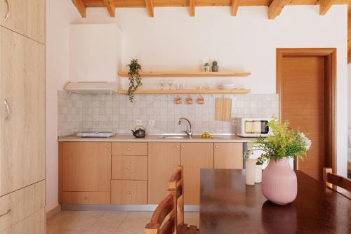 una cocina con una mesa y un jarrón con flores. en The Island Life Apartments by Konnect, Ipsos Beach en Ýpsos