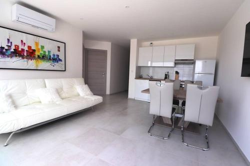 un salon avec un canapé blanc et une cuisine dans l'établissement T3 Villas ACUM- Agosta plage - vue MER et Îles sanguinaires, à Porticcio