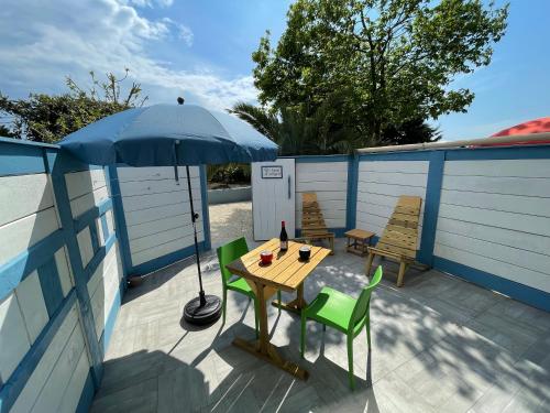 a table and chairs with an umbrella on a patio at Le banc d'Arguin in La Teste-de-Buch