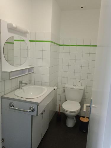 a bathroom with a toilet and a sink and a mirror at Le village Gr34 louannec in Louannec