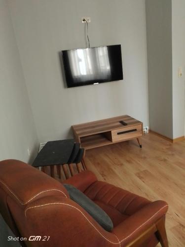 ein Wohnzimmer mit einem Sofa und einem Flachbild-TV in der Unterkunft Siesta Suit in Trabzon