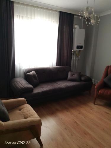 ein Wohnzimmer mit einem Sofa und einem Fenster in der Unterkunft Siesta Suit in Trabzon