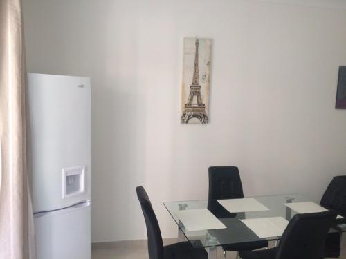 una sala da pranzo con tavolo e frigorifero di Cozy 1 bedroom apt very close to the seaside B1B a San Pawl il-Baħar