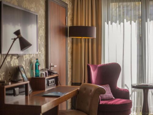 a room with a desk and a chair and a lamp at Aspria Hamburg Uhlenhorst Sport & Spa in Hamburg