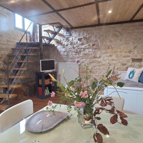un vase de fleurs sur une table dans une pièce dans l'établissement La Mezzabulle, à Chapaize