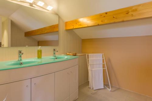 uma casa de banho com um lavatório e um espelho em Les Pâtis 