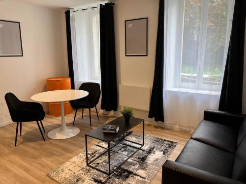 a living room with a couch and a table and chairs at ELEGANT PIERRE FABRE-T1-Wifi-Vélo in Castelnaudary