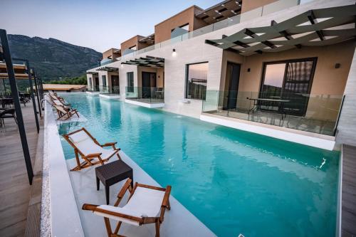 a view of the pool at a resort with chairs at Serenity Suites Sea View Houses - Happy Rentals in Káto Xirokhórion