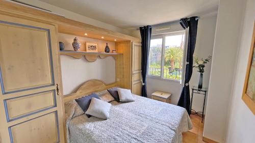 une chambre avec un lit et une fenêtre dans l'établissement Port Marine, à Sainte-Maxime