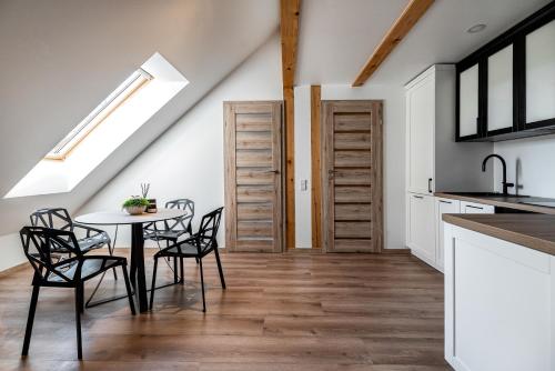 - une cuisine et une salle à manger avec une table et des chaises dans l'établissement Apartamentai Puodžių 27, à Klaipėda