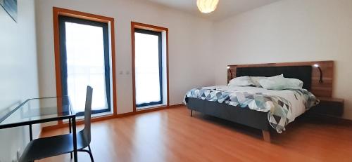 a bedroom with a bed and a glass table at CASA AURA in Olhão