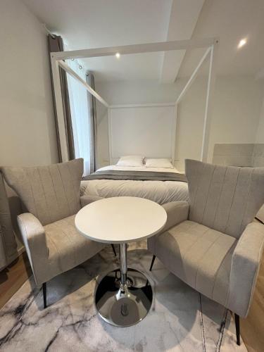 une pièce avec deux chaises, une table et un lit dans l'établissement SUITE PRIVEE RIQUET-wifi-Vélo, à Castelnaudary