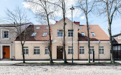 a building with trees in front of it at Apartamentai Puodžių 27 in Klaipėda