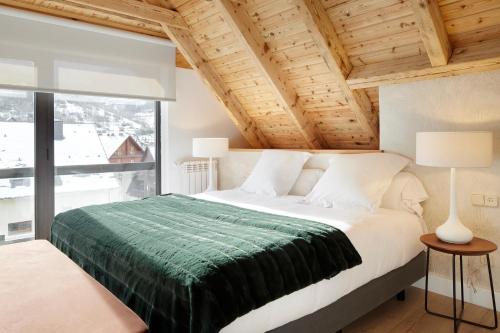 a bedroom with a bed and a large window at Inuit by FeelFree Rentals in Vielha