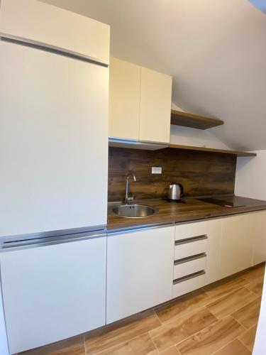 a kitchen with white cabinets and a sink at Villa Blanca in Risan