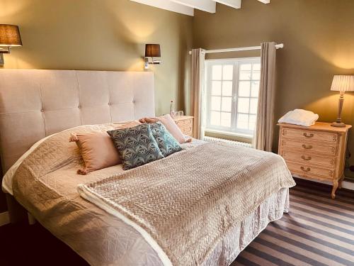 a bedroom with a large white bed with a window at Auberge d'Inxent in Inxent