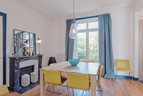 une salle à manger avec une table et des chaises et une cheminée dans l'établissement Villa Jules Simon, à Saint-Malo