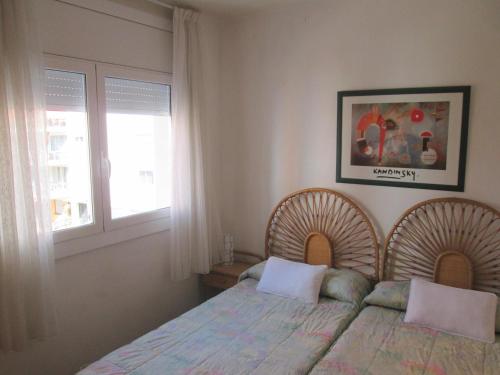 ein Schlafzimmer mit einem Bett mit zwei Kissen und einem Fenster in der Unterkunft apartamento 5 estrellas fanals in Lloret de Mar