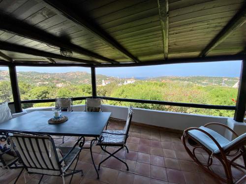 a table and chairs on a balcony with a view at Seaview Apartment in Porto Cervo in Porto Cervo