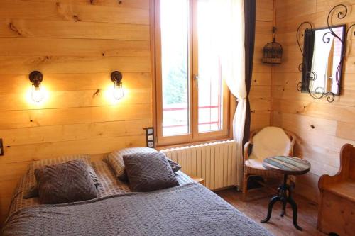 a bedroom with a bed in a wooden wall at La Maison du Bonheur in Anlhiac