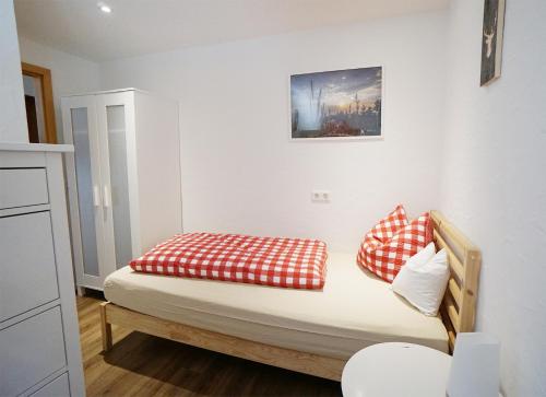 a bed with red and white pillows in a room at Kandel - Stubenhof, Black Forest in Simonswald