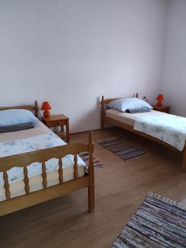 two beds in a room with two rugs at Apartments Pasta in Poljica
