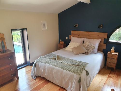 une chambre avec un grand lit et une fenêtre dans l'établissement Gîtes de Charme 