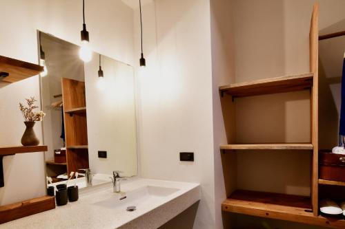 La salle de bains est pourvue d'un lavabo et d'un miroir. dans l'établissement Coconut Lane Bangkok, à Bangkok
