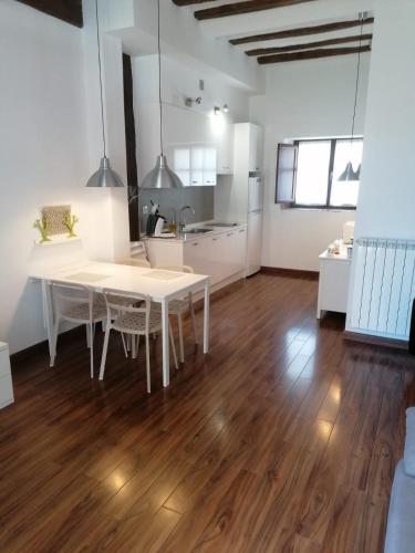 a kitchen and dining room with a white table in a room at Apartamentos Turísticos Rincones del Vino in Ezcaray