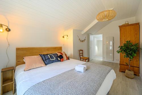 a bedroom with a large bed with pillows on it at Le Krisco, une maisonnette en cœur de ville avec un parking privé in Vannes